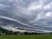 Langgezogene dunkle Wolkenbänder nähern sich Aschau von Westen